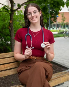 Female college student seated on bench.